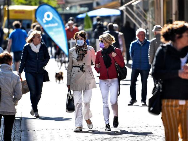 People walk in a shopping street in Gelsenkirchen, Germany, as many smaller stores are allowed to open on Monday, April 20, 2020. Europe's biggest economy, starts reopening some of its stores and factories after weeks of lockdown due to the new coronavirus outbreak. (AP Photo/Martin Meissner)