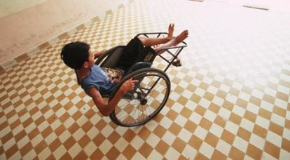 Uma criança com deficiência brinca com sua cadeira de rodas.