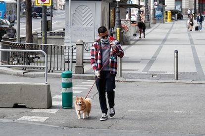 De máscara, homem passeia com cachorro em Madri, no domingo. 
