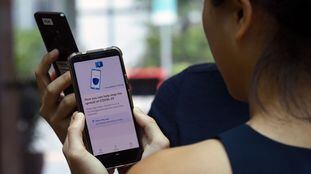 Funcionários do Governo de Singapura fazem uma demonstração do aplicativo TraceTogether.