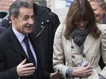 O ex-presidente francês Nicolás Sarkozy e sua esposa, Carla Bruni-Sarkozy, saem de um despacho de voto durante o primeiro turno das eleições primárias