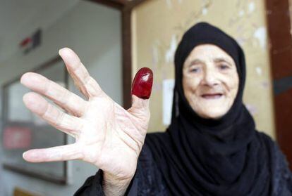 Egípcia exibe polegar marcado com tinta após votar.