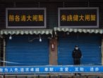 (FILES) In this file photo taken on January 24, 2020 a security guard stands outside the Huanan Seafood Wholesale Market where the coronavirus was detected in Wuhan. - An international expert mission to Wuhan has concluded that it was very likely that Covid first passed to humans from a bat through an intermediary animal, while all but ruling out a lab incident. The experts said that the intermediary host hypothesis was deemed "likely to very likely", while the theory that the virus escaped from a laboratory was seen as "extremely unlikely", according to the final version of the long-awaited report, of which AFP obtained a copy on March 29, 2021 before the official release. (Photo by Hector RETAMAL / AFP)