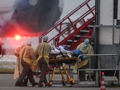 Agentes de saúde fazem a transferência de um paciente com coronavírus a outra unidade de UTI do país em um avião militar nesta sexta-feira, em Memmingen.