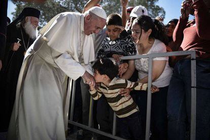 Uma criança beija ao Papa durante sua visita ao centro de emigrantes de Moria na ilha de Lesbos (Grécia), o 16 de abril de 2016.