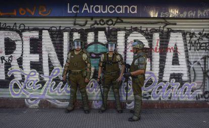 Policiais chilenos fazem a segurança de um supermercado fechado pelos protestos em Santiago.