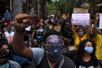 Homem ergue o punho fechado, símbolo da luta antirracista, em protesto no Rio de Janeiro em 31 de maio.
