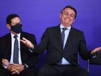 Brazilian President Jair Bolsonaro (R) gestures next to his Vice-President Hamilton Mourao during the launch of the Alliance for Volunteering aid program at Planalto Palace in Brasilia, on November 9, 2020, amid the new coronavirus pandemic. - Bolsonaro, even after 48 hours of confirmation of Joe Biden's victory in the US election, remains without making any comment on the issue. (Photo by EVARISTO SA / AFP)