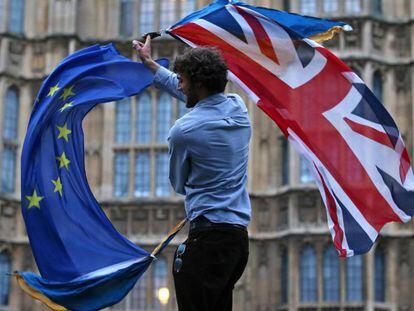 Um homem com bandeiras britânicas e da UE em Londres.