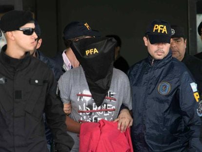 Adolescente de 15 anos é conduzido por policiais no aeroporto de Ezeiza, em Buenos Aires, sob a acusação de matar outro menor no bairro de Flores.