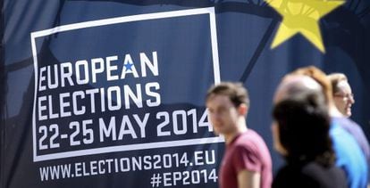 Transeuntes passam por cartaz alusivo às eleições europeias, em Bruxelas.
