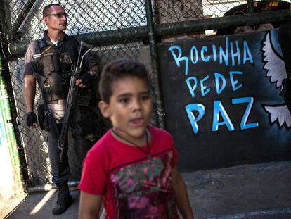 Uma criança e um policial na quadra onde moradores da Rocinha pediram à volta da sua rotina.