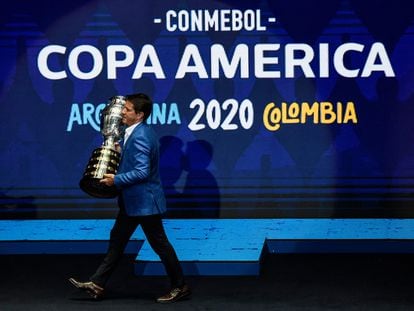 O ex-jogador Juninho Paulista carrega o troféu da Copa América durante a presentação da edição de 2020, adiada pela pandemia.