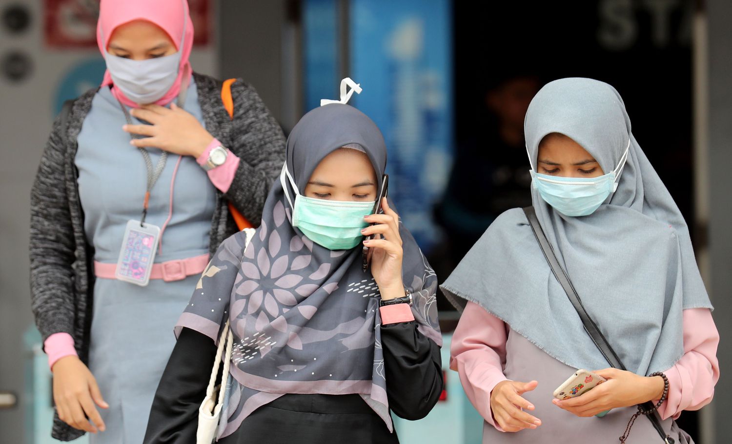 Mulheres usam máscaras de proteção na Indonésia, neste sábado, 29 de fevereiro.