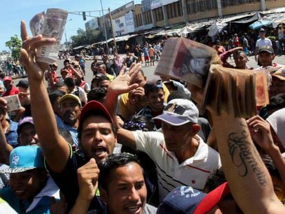 Venezuelanos mostram notas de 100 bolívares