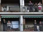 Varios vecinos de Alcalá de Henares aplauden desde sus balcones.