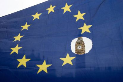 O Big Ben observa-se através de uma bandeira europeia furada.