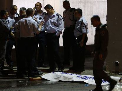 Policiais israelenses junto ao corpo do agressor/ YEHUDA PERETZ (AFP)