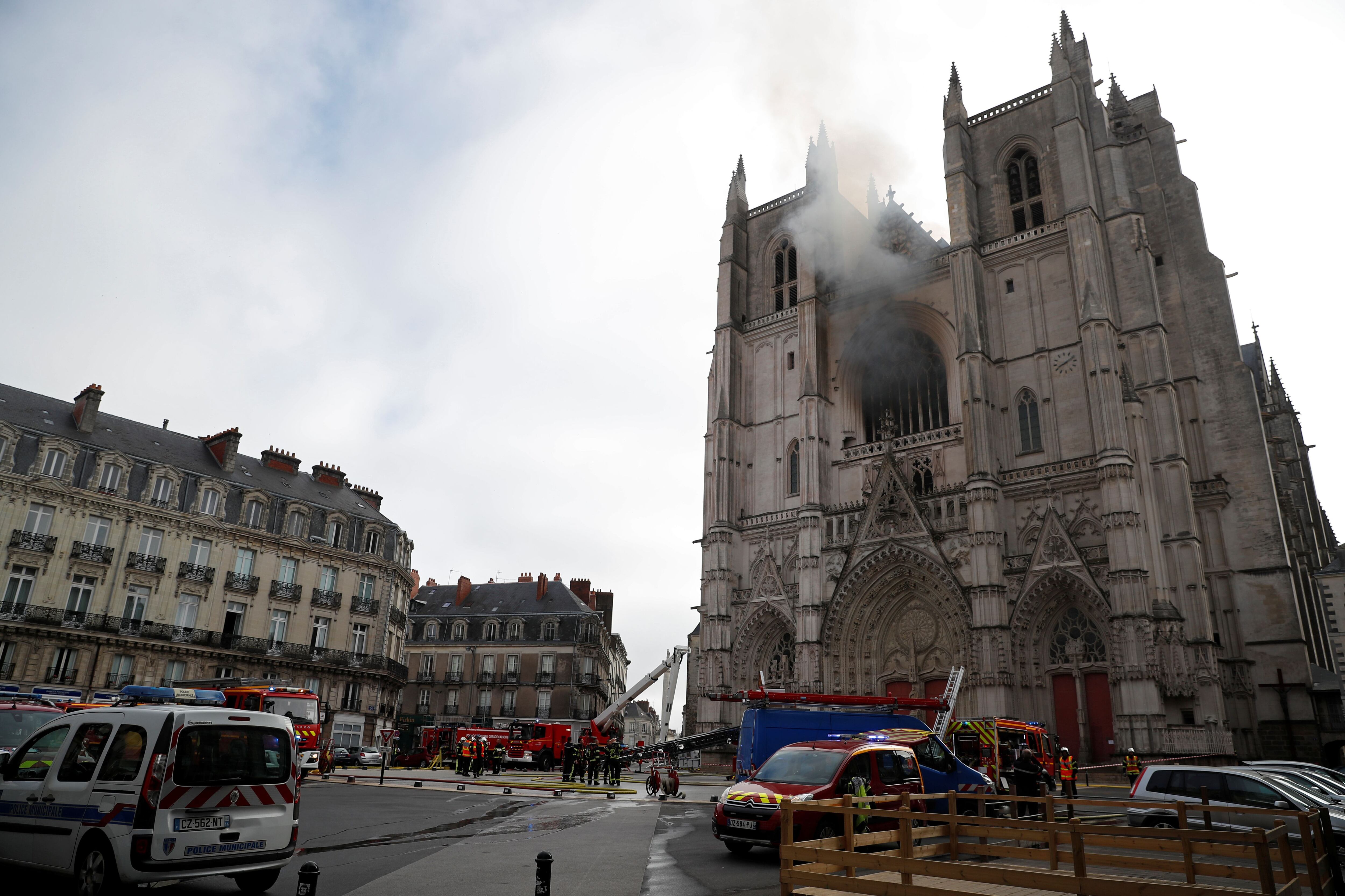 Imagem da catedral com a zona restrita e os bombeiros trabalhando para extinguir o fogo.