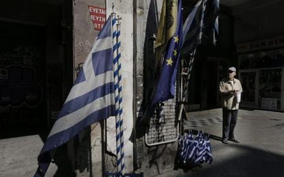 Um idoso em frente a uma loja que vende bandeiras gregas e da UE no centro de Atenas.