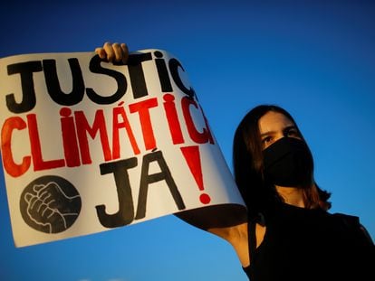 Ativista mostra cartaz pedindo justiça climática durante manifestação em Brasília, em setembro de 2020.