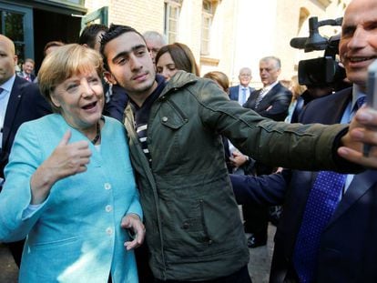 Anas Modamani com Angela Merkel, quando ele tirou uma selfie com a chanceler.