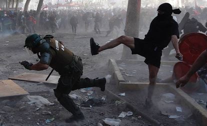 Manifestantes e policiais se enfrentam durante a manifestação em Santiago, nesta terça-feira.