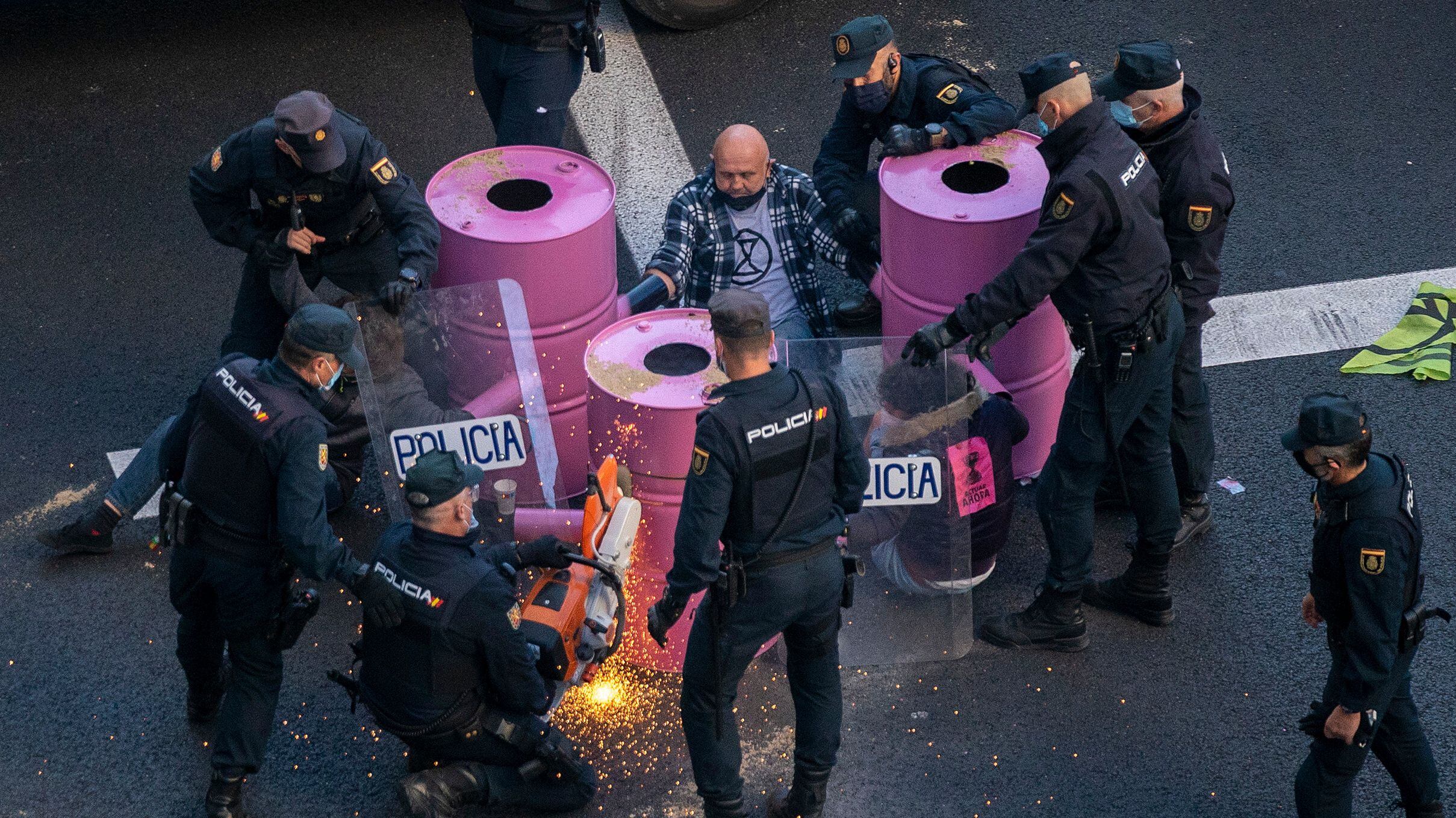 Agentes da polícia tentam retirar ativistas do grupo Extinction Rebellion que interromperam o tráfego na avenida Gran Via, em Madri, nesta segunda-feira. 