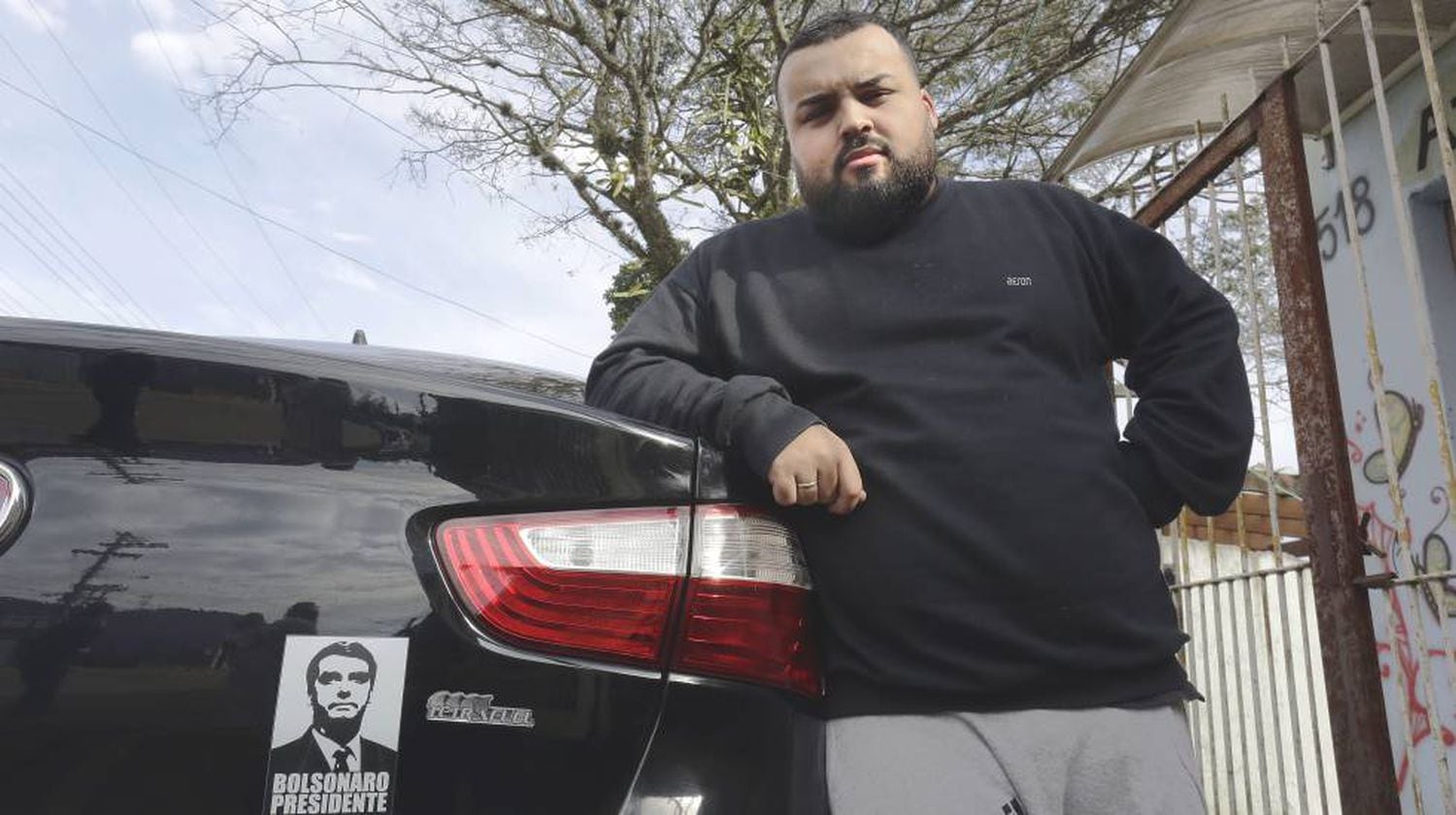 Anriel do Prado Neves, de 24 anos, mostra o adesivo de Jair Bolsonaro no carro que dirige para um aplicativo.