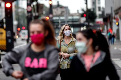 Pessoas com máscaras caminham em São Paulo.
