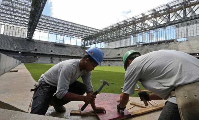 Operários trabalham nas obras da Arena da Baixada.