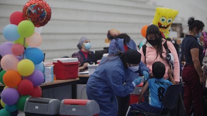 Uma funcionária de unidade de saúde administra uma vacina da Sinovac a uma criança em Cuenca, Equador, em 23 de novembro.