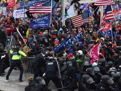 Multidão de seguidores de Donald Trump quebra a barreira de segurança levantada pela polícia diante do Capitólio em 6 de janeiro.