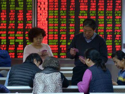 Investidores jogam baralho numa corretora de títulos em Pequim.