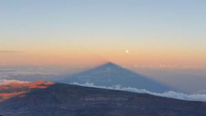 A sombra do vulcão se projeta na atmosfera, ao lado da superlua, deixando o Observatório do Teide à esquerda.
