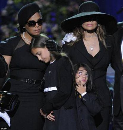 A filha de Michael Jackson, Paris, apoiada em Janet Jackson durante as cerimônias fúnebres de seu pai. Ela alertou para o fato de que seu pai não canta no disco póstumo.