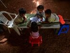 Unos niños indígenas emberá consultan un libro mientras dan clase en su comunidad en marzo de 2021 en Puru Embera, provincia de Colon, Panamá. En tiempos de pandemia y sin conexión a internet, estudiantes como estos reciben lecciones gracias a profesores que se desplazan a sus comunidades.
