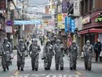 Soldados surcoreanos desinfectan una calle de Seúl.