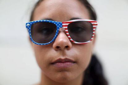 Estudante cuba posa em Havana com óculos enfeitados com a bandeira dos EUA.