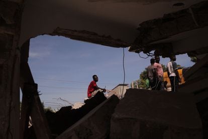 Um grupo de pessoas remove escombros em uma rua de Los Cayos