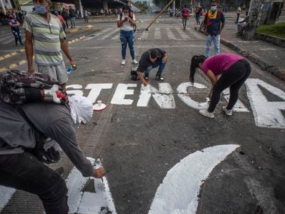 Jovens colombianos fazem pichações de protesto em uma avenida da cidade de Cali, Colômbia, em 8 de maio