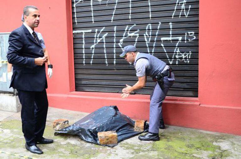Policiais ao lado de partes de um corpo achado em São Paulo.