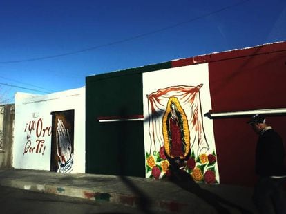 Um mural com imagem da virgem de Guadalupe sobre a bandeira mexicana em Ciudad Juárez.