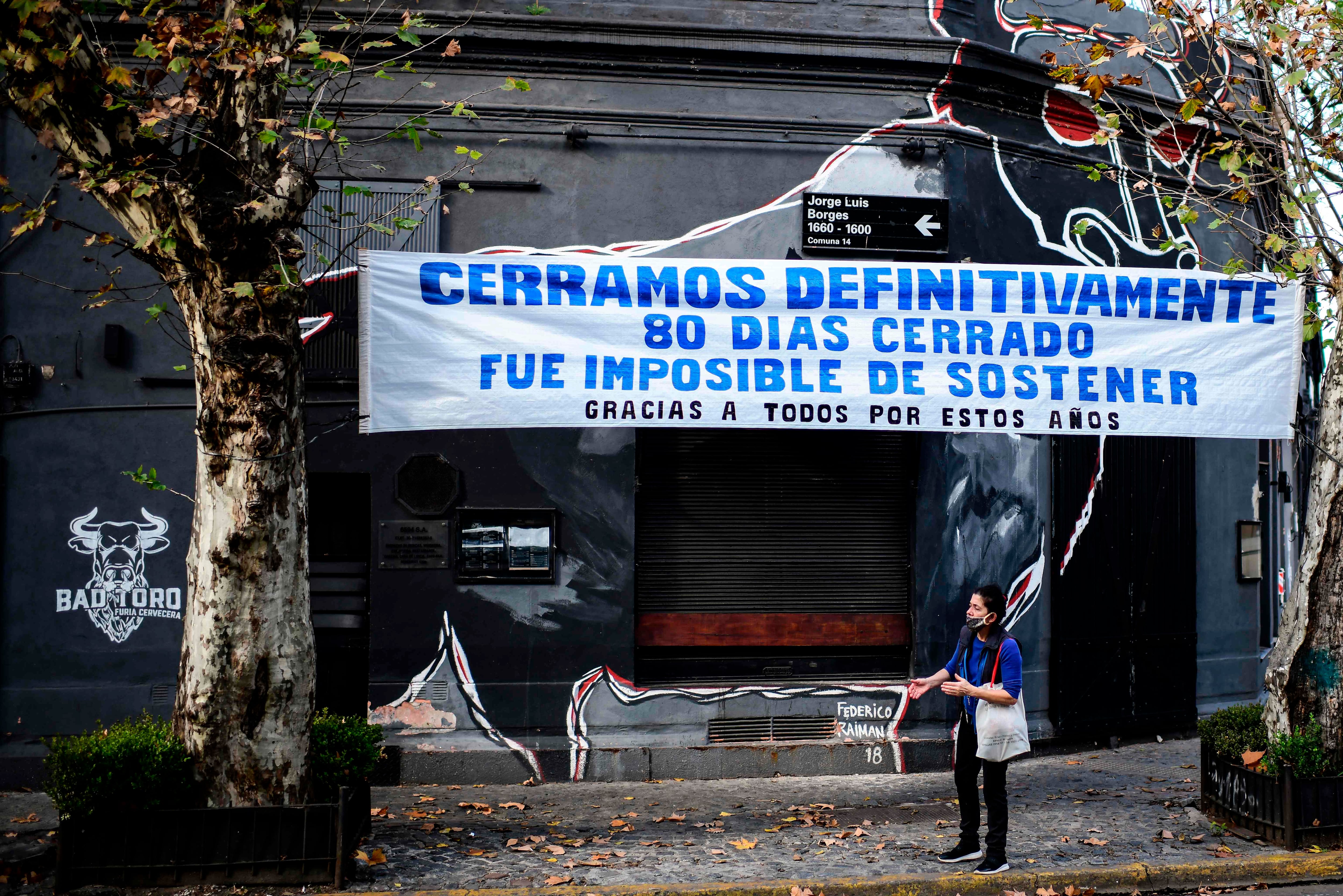 Um comércio fechado durante a pandemia em Buenos Aires exibe uma faixa de protesto na fachada.