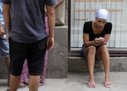 Uma mulher utiliza seu celular nas ruas de Havana.