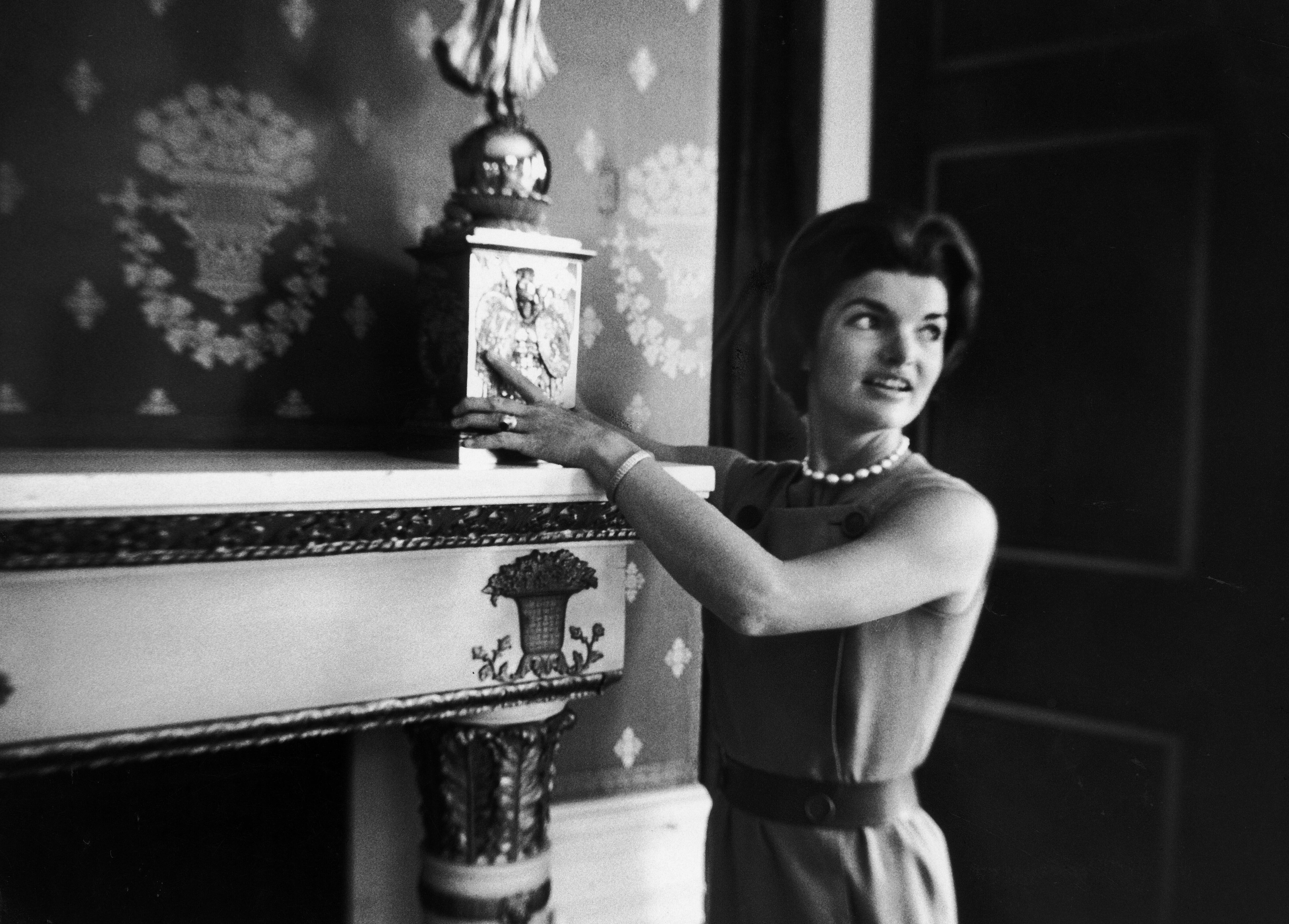 Jackie Kennedy mostra um candelabro de James Monroe.