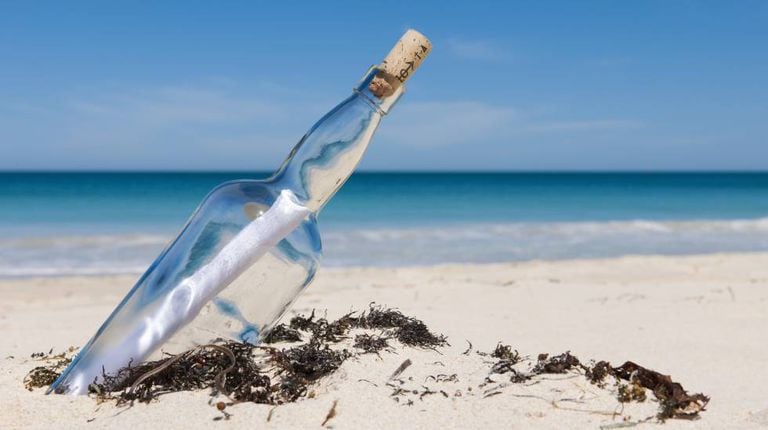 Uma mensagem dentro de uma garrafa numa praia, em uma imagem de arquivo