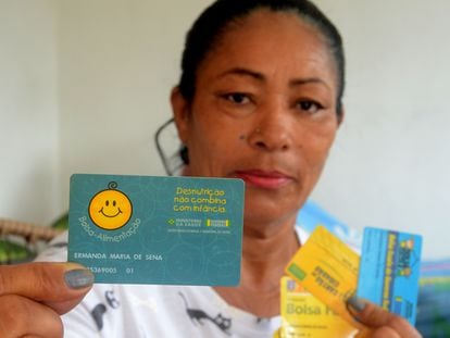 Ermanda Maria de Sena, a primeira usuária cadastrada do Bolsa Família, mostra o cartão do Bolsa-Alimentação com o número 01
