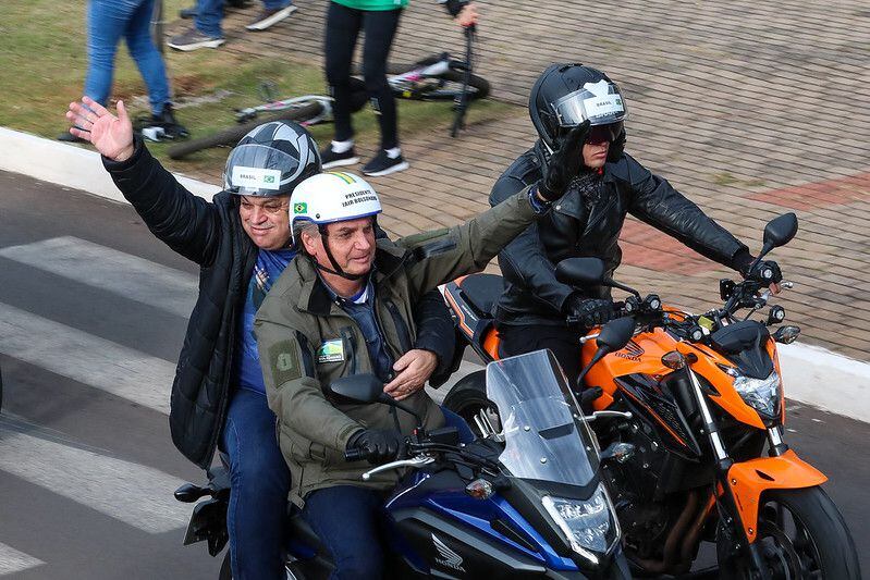 O presidente Jair Bolsonaro leva o prefeito de Chapecó, João Rodrigues, na garupa da moto durante a 'motociata' deste sábado, 26 de junho, pelas ruas de Santa Catarina.