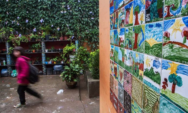 Muro do pátio interno da Amorim Lima estampa a arte dos alunos. Crianças também são responsáveis por cuidar das plantas.